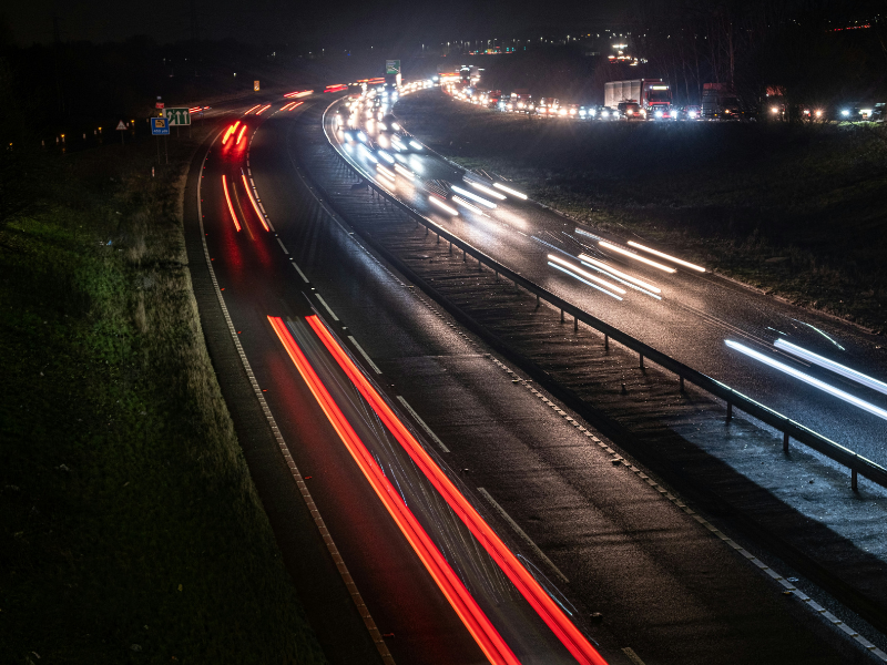Vehicles on a dual carriageway at night that are looking to reduce fuel costs.